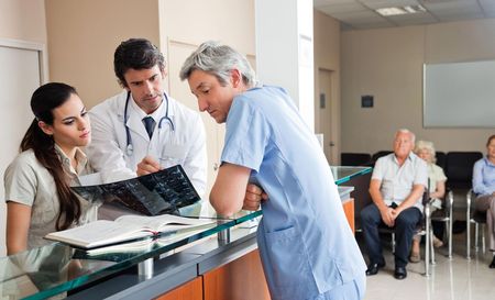 a doctor and nurse are talking to a patient in a hospital waiting room